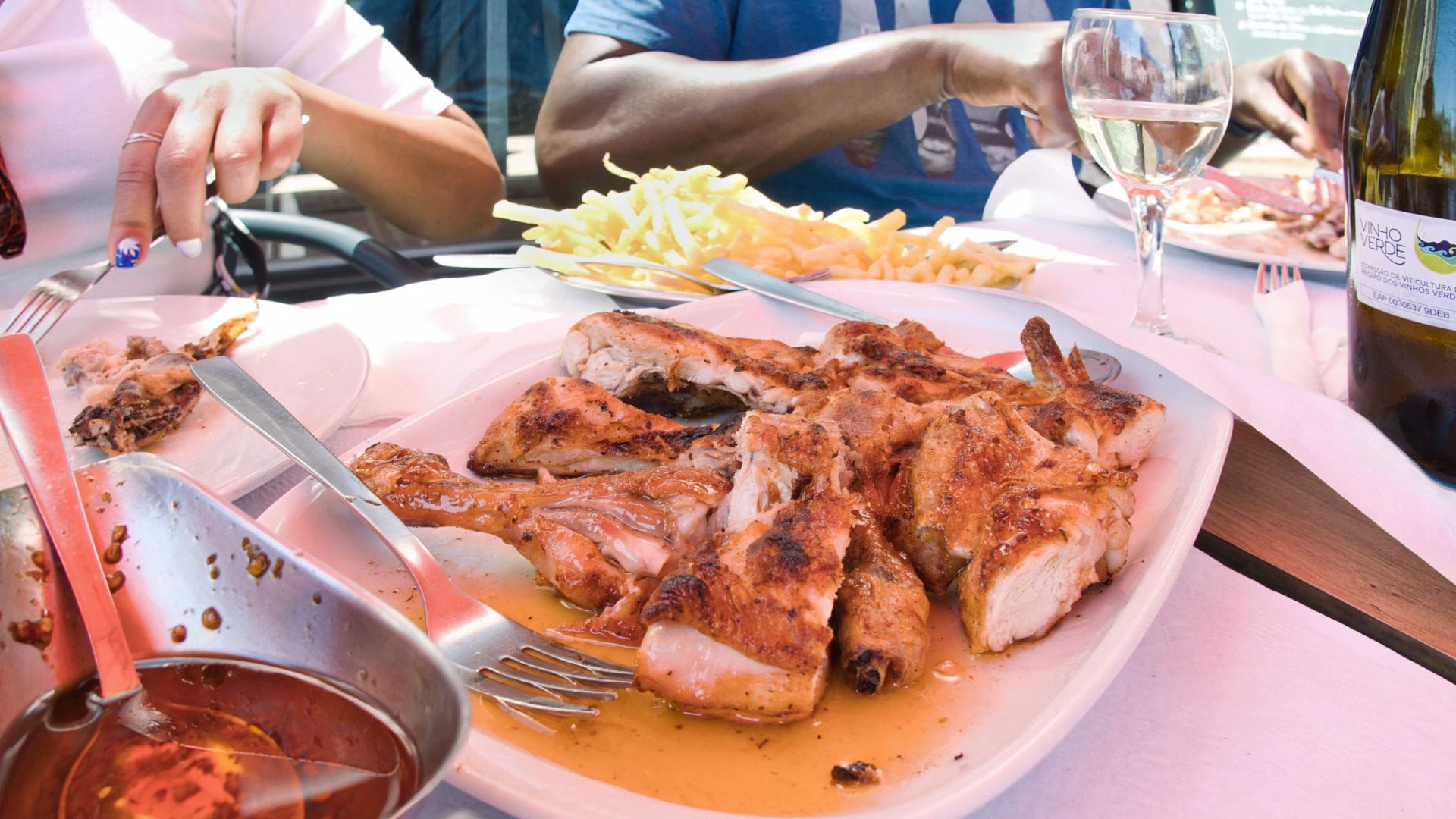 Traditional Portuguese grilled chicken with fries and Vinho Verde, served during a Cooltour Oporto food tour