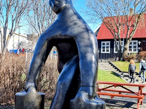 A picture of the Vatnsberinn Statue in Reykjavik - showing a woman carrying 2 water buckets