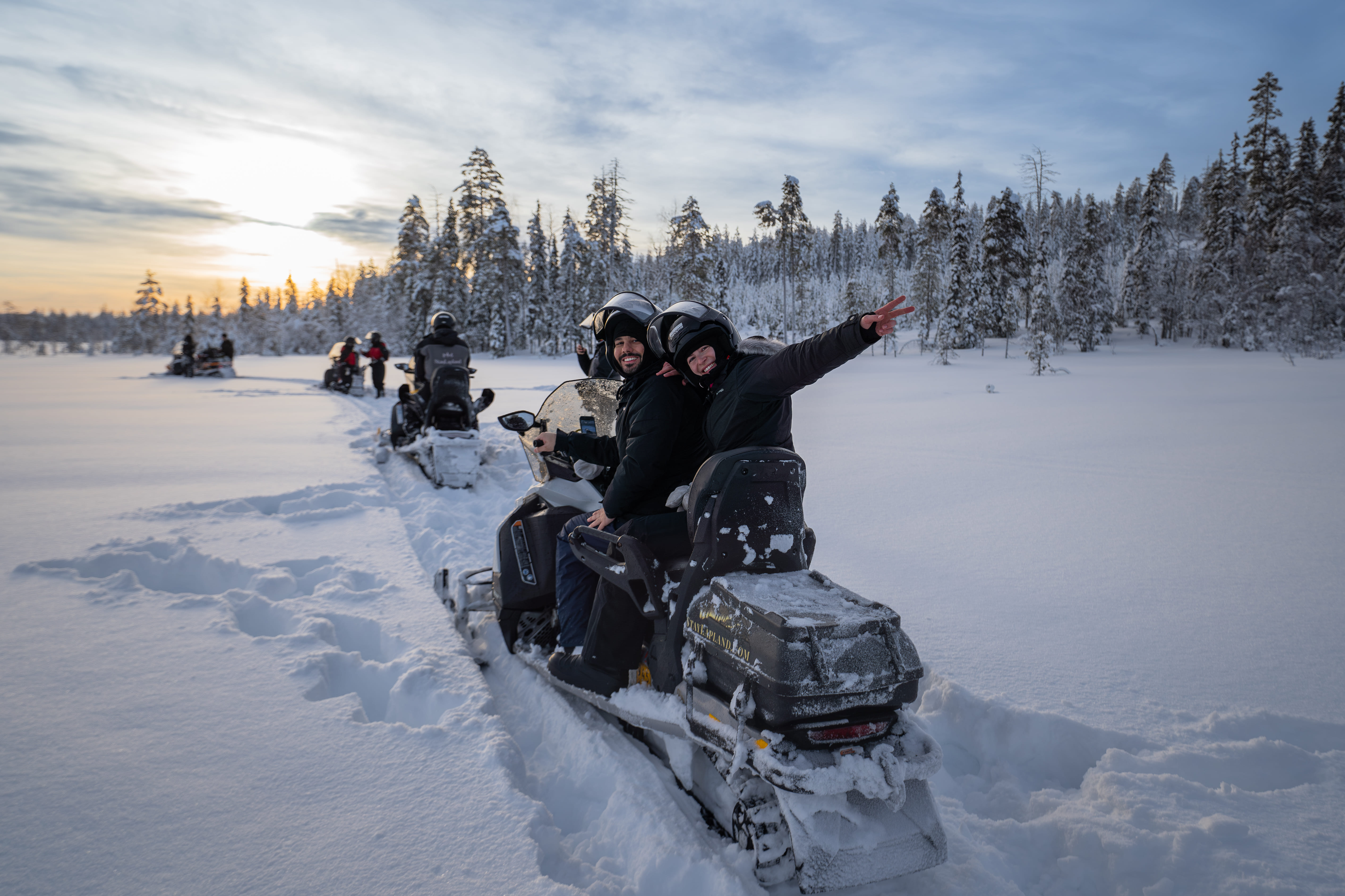 A guest enjoying a snowmobile ride through the snow-covered terrain during StayLapland's Kuoksa Husky & Snowmobile Adventure.