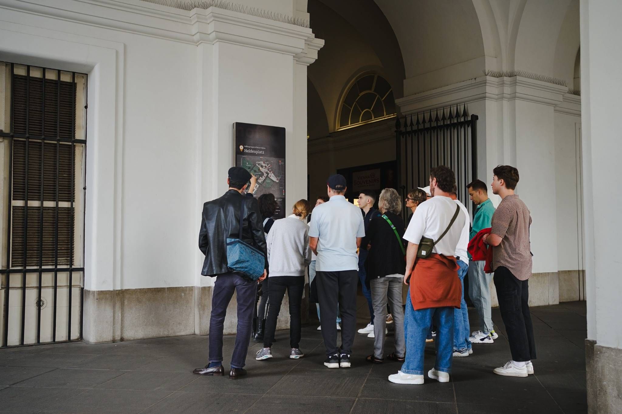 People gathered near an arched entrance of Hofburg Palace in Vienna