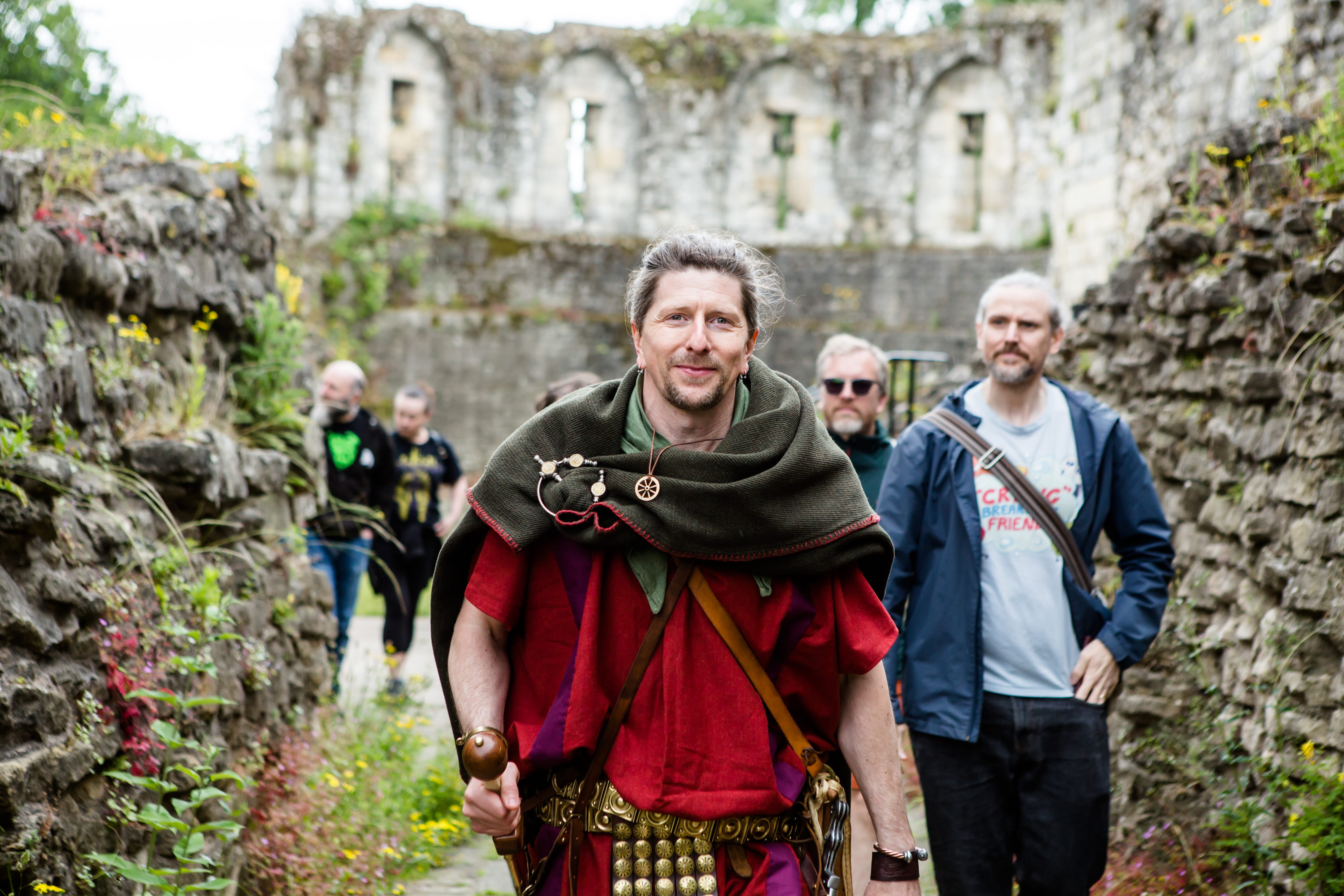 The Original Roman Walk's guide, dressed as a Roman legionary, in front of the Multangular Tower, in the Museum Gardens, with guests.
