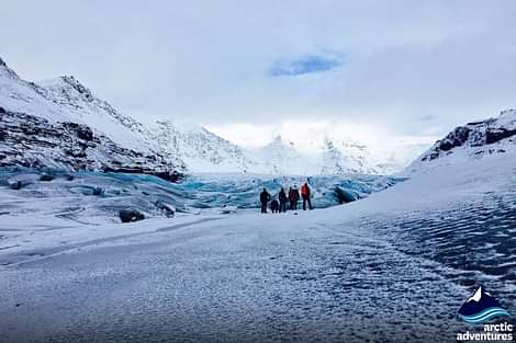 A group of people exploring glacier during South coast and northern lights tour