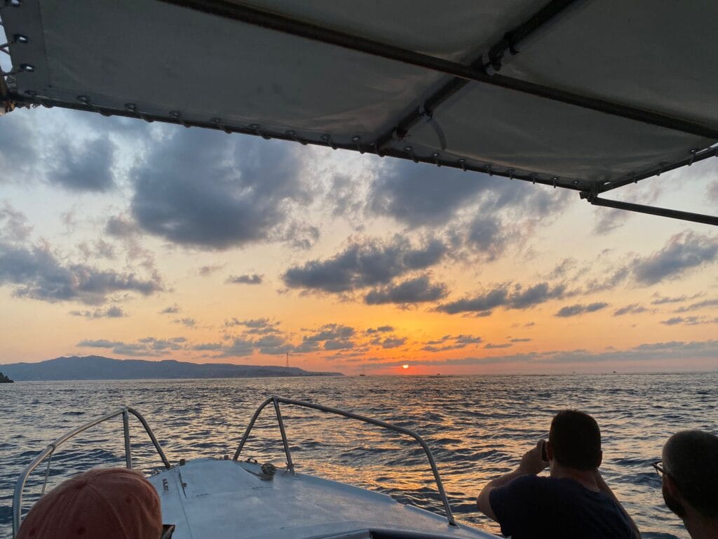 Vista del tramonto dalla barca lungo la Costa Viola con acque di mare calme