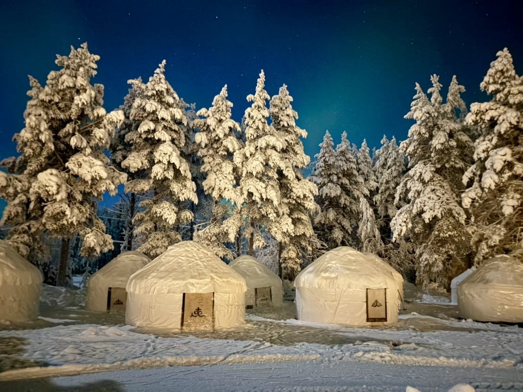 Traditional white yurts in a snowy forest near Levi, Finnish Lapland.