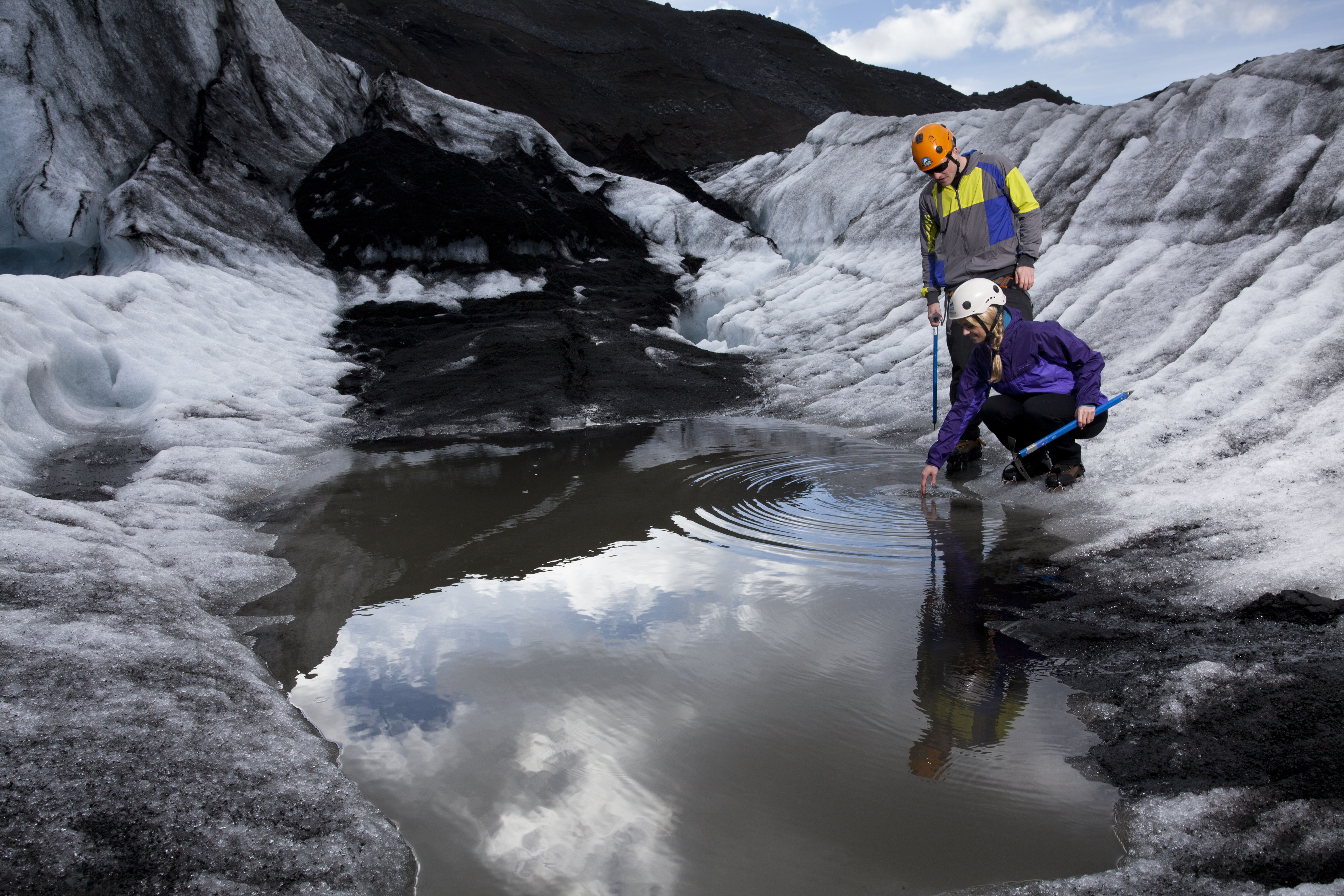 couple filling up a bottle of water of a Falljökull Glacier during arctic adventures 6 day tour