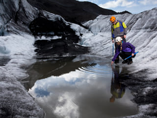 couple filling up a bottle of water of a Falljökull Glacier during arctic adventures 6 day tour