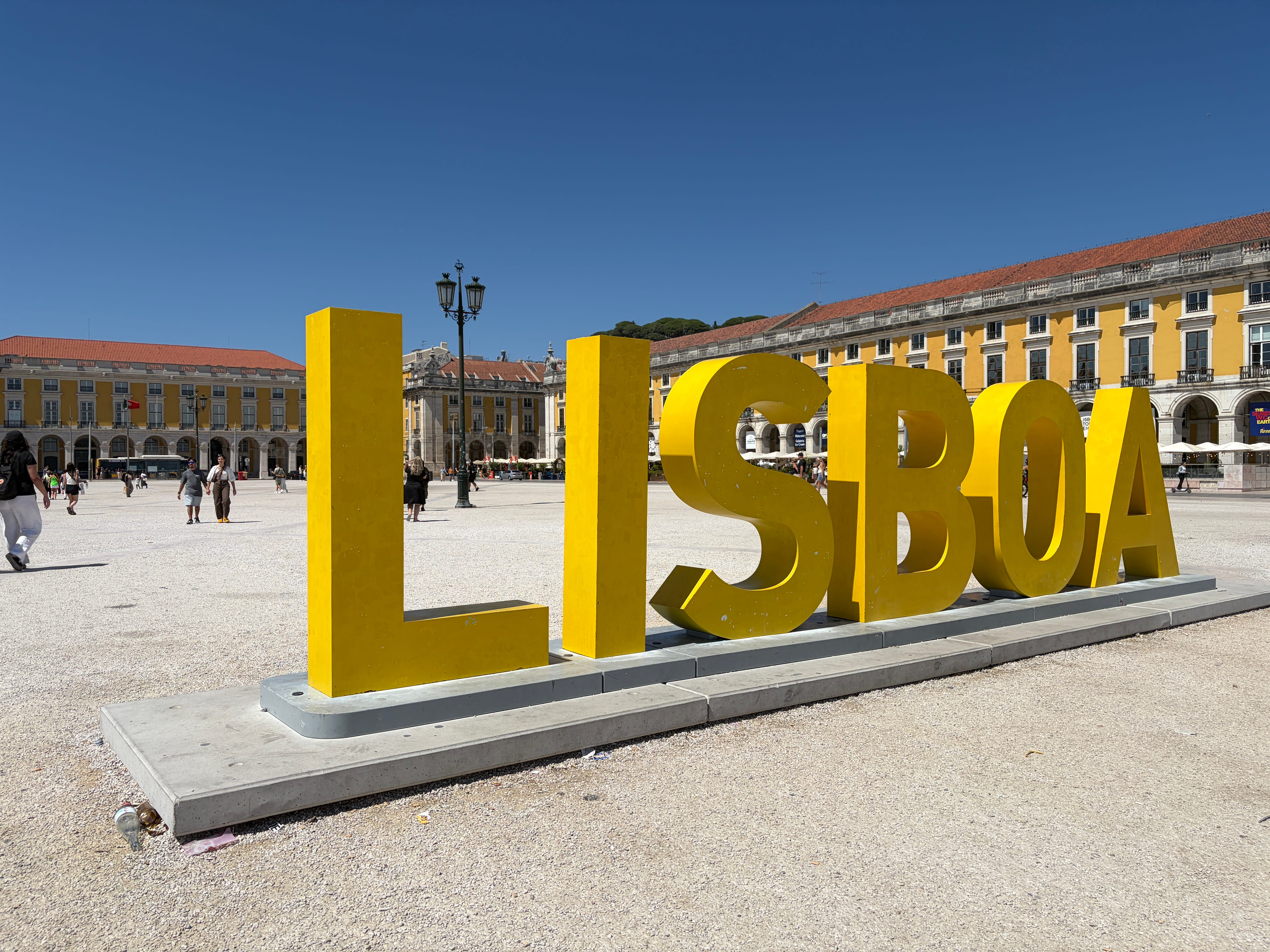 Tourists exploring the authentic cobblestone streets and colorful houses of Alfama, Lisbon's oldest district