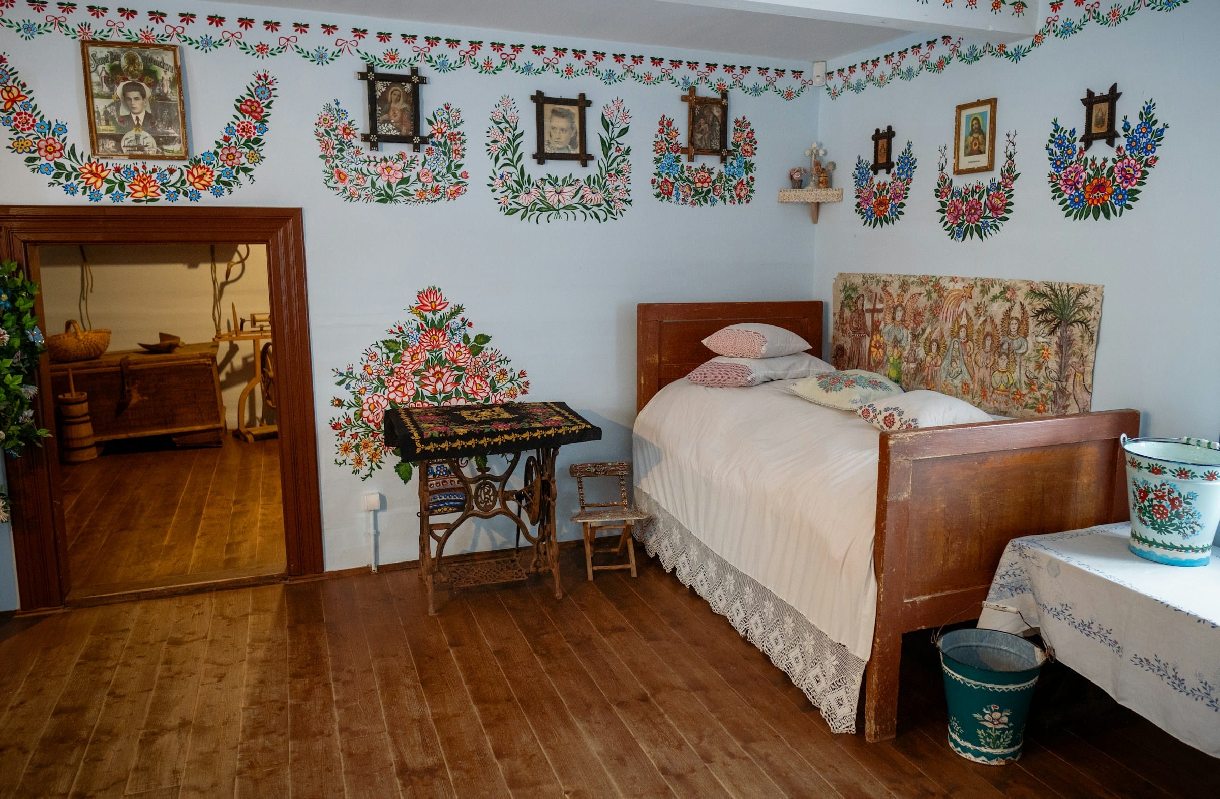 Zalipie museum interior painted room — folk costume traditional bedroom floral painted walls Poland