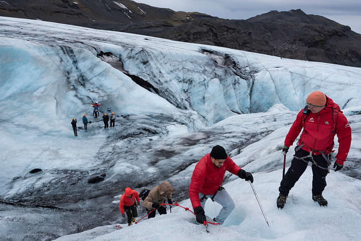 Group of people hiking and climbing on a glacier