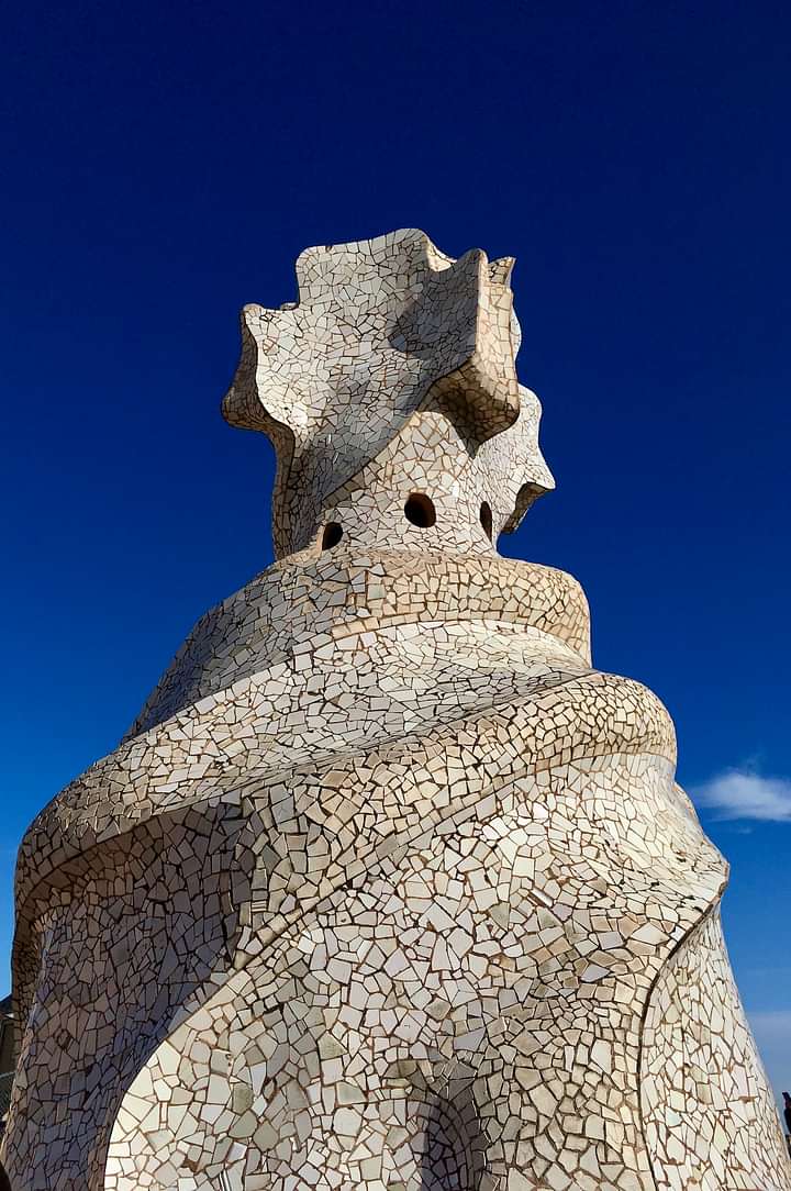 A sculpture covered with white broken tiles - in the background the blue sky