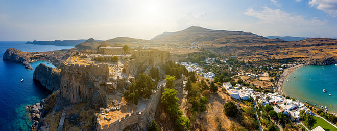 Breathtaking panoramic aerial view of Lindos town from the Acropolis of Lindos in Rhodes, Greece. Amazing colorful sunset scenery in Rhodes.