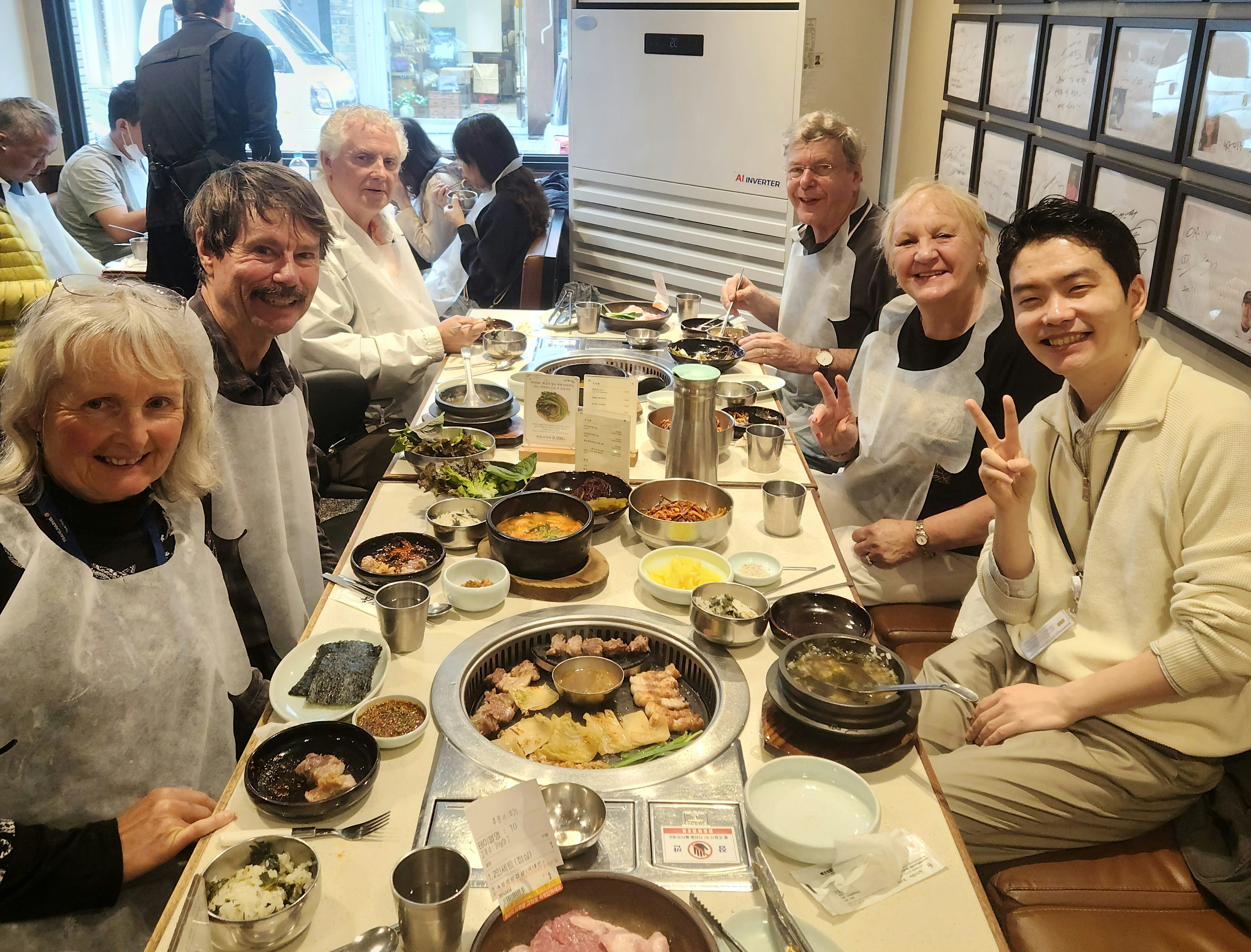 A group of travelers enjoying a Korean BBQ meal together at Matchandeul Bupyeong Branch, sharing food and smiling around the table