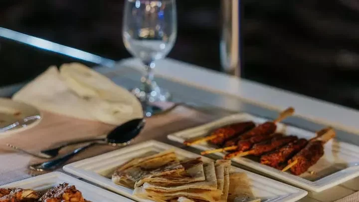A spread of skewers, flatbread, and other appetizers sits on a white table at Alexandra Sea Lounge.