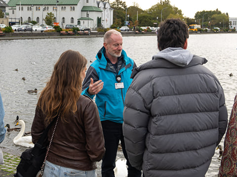 Guide speaking to a small group outdoors in an urban setting
