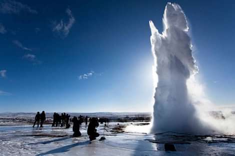 People enjoying the view of geyser during South coast and northern lights tour