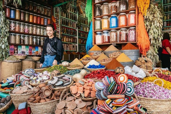 A colorful scene inside the souks of Marrakech, where your local guide leads you through narrow alleys filled with Moroccan crafts and vibrant textiles — a truly authentic Marrakech experience.