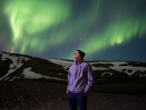 A man enjoying the Northern lights during Northern lights jeep tour Iceland