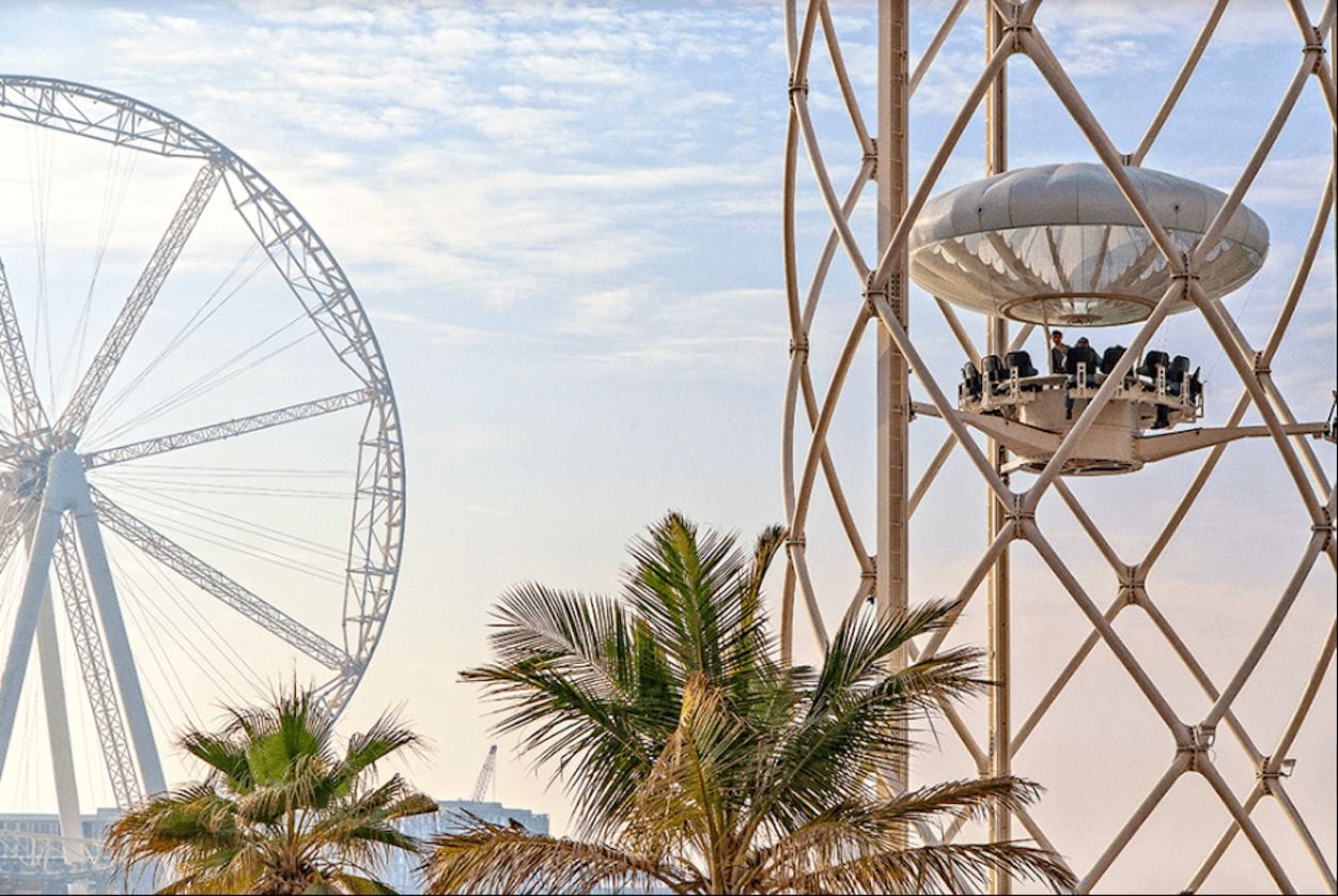 A close-up of a gourmet dish with the Dubai skyline in the background.