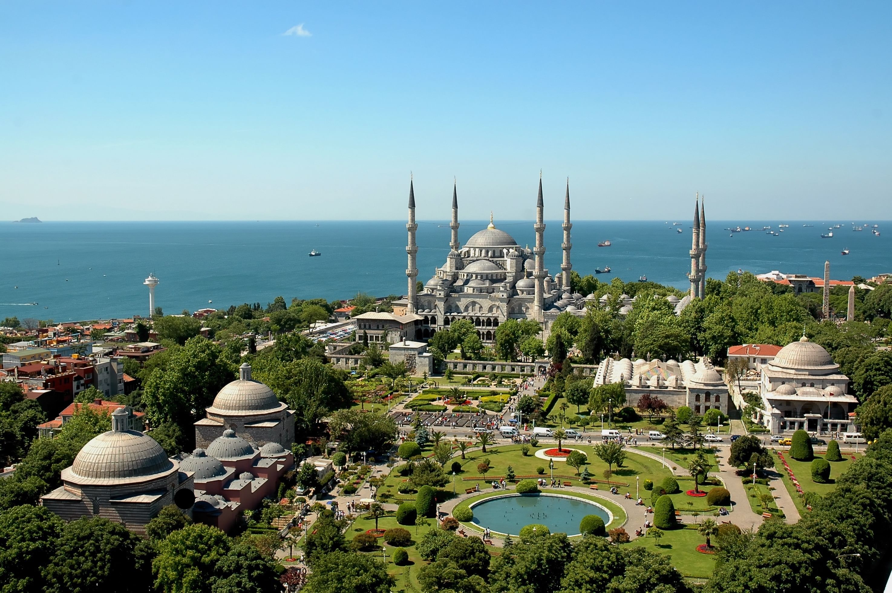 “Panoramic view of Istanbul’s Blue Mosque with its large central dome, six slender minarets, and surrounding cityscape under a clear sky.”