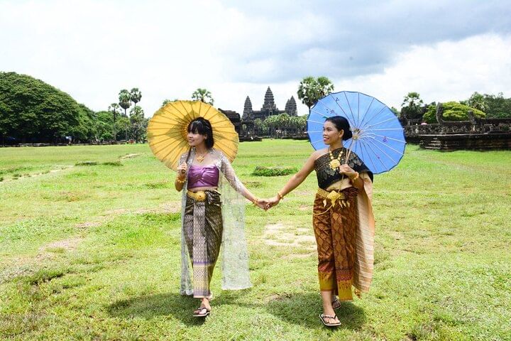 Traveler wearing traditional Khmer dress in front of Angkor Wat during a cultural photo tour