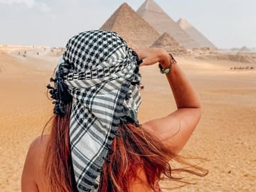 Traveler capturing panoramic desert horizon and ancient pyramids