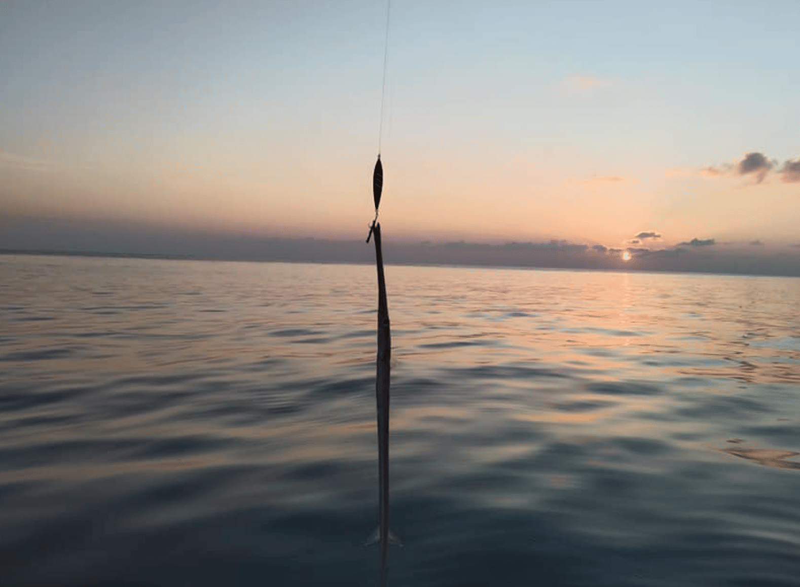 Sunset over the Indian Ocean with a traditional pole-and-line fishing setup during a sunset fishing trip in Fuvahmulah.