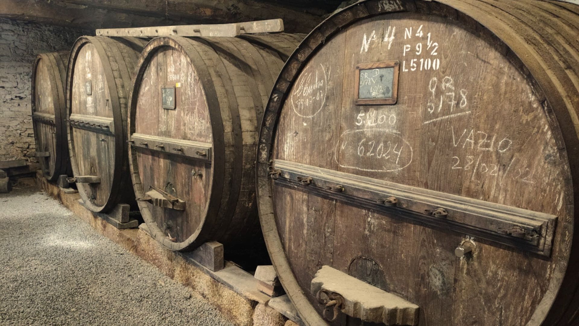 Image of old barrels of Port wine in a winery visit on Cooltour Oporto's Douro Valley Wine Tour from Porto