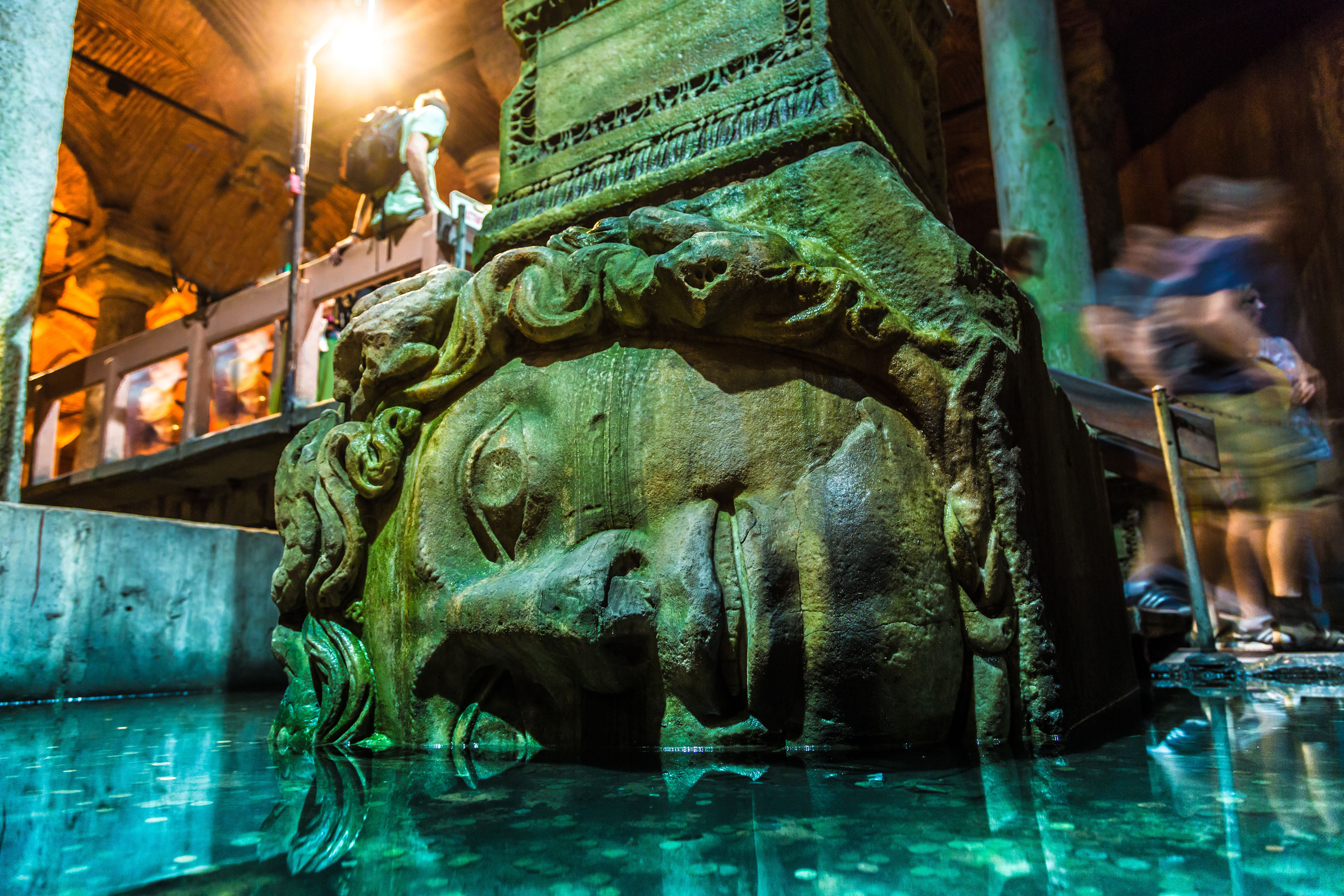 “Stone Medusa Head sculpture placed sideways beneath a column in Istanbul’s Basilica Cistern, surrounded by water and ancient stone pillars.