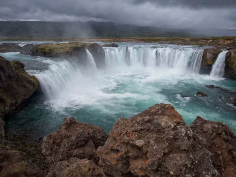 Wide-angle view of Goðafoss with surrounding cliffs