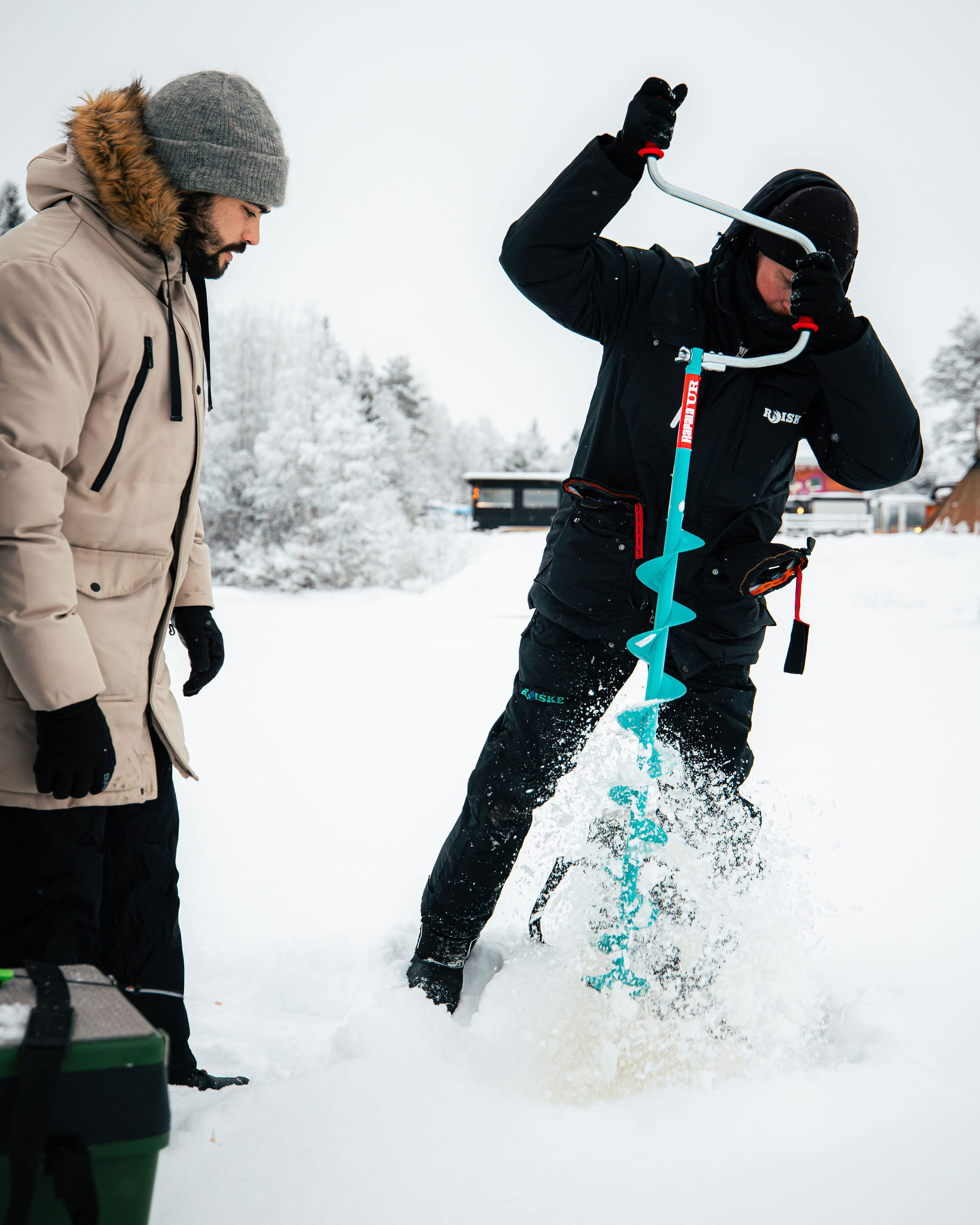 Local guide drilling ice fishing hole for the clients