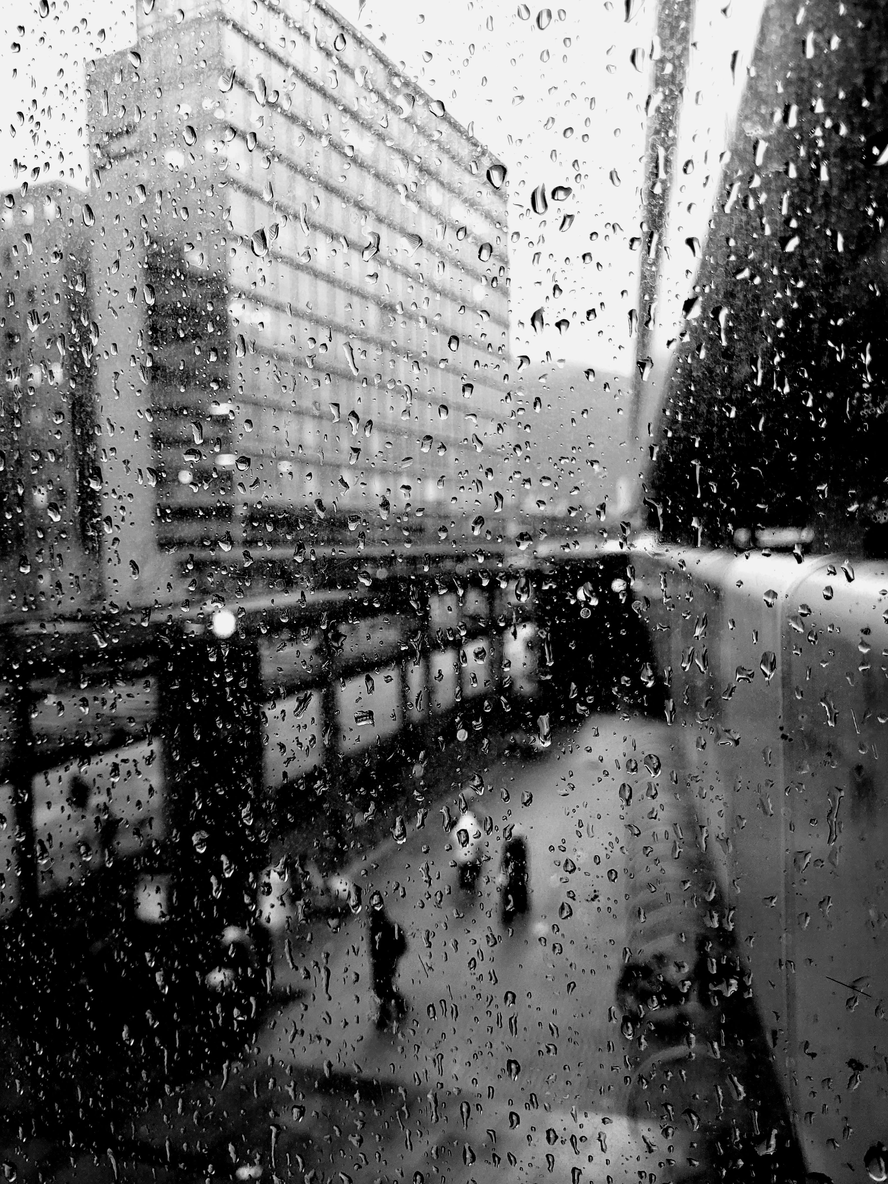 Black-and-white city scene seen through rain-covered glass, showing the moody urban photography explored during the photowalk.
