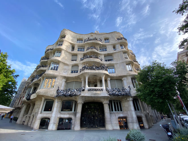 A massive building in sandstone color with a curvy façade