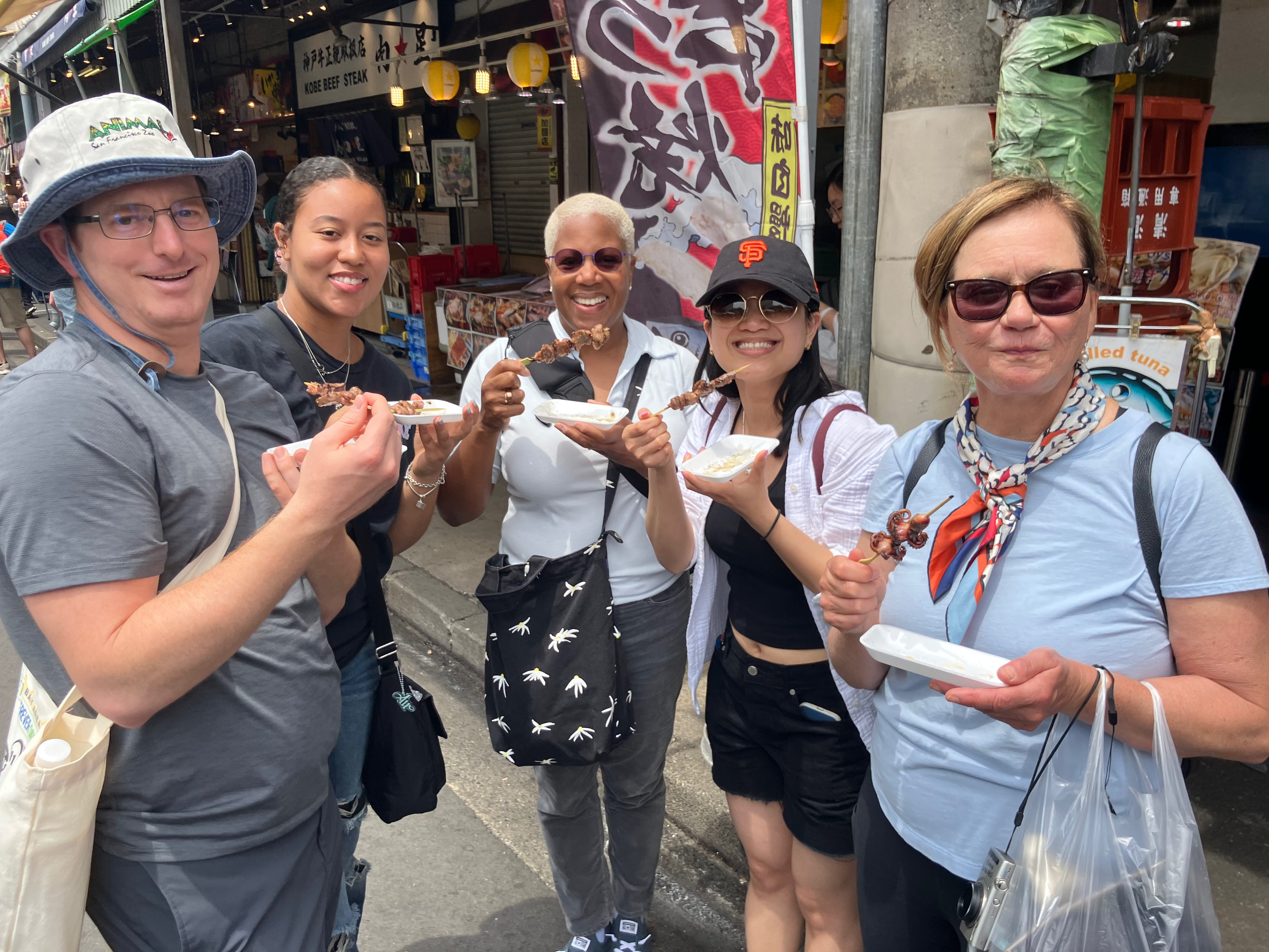 Visitors eating octopus skewers