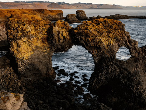 Coastal view of basalt rock formations and waves crashing into the shore below