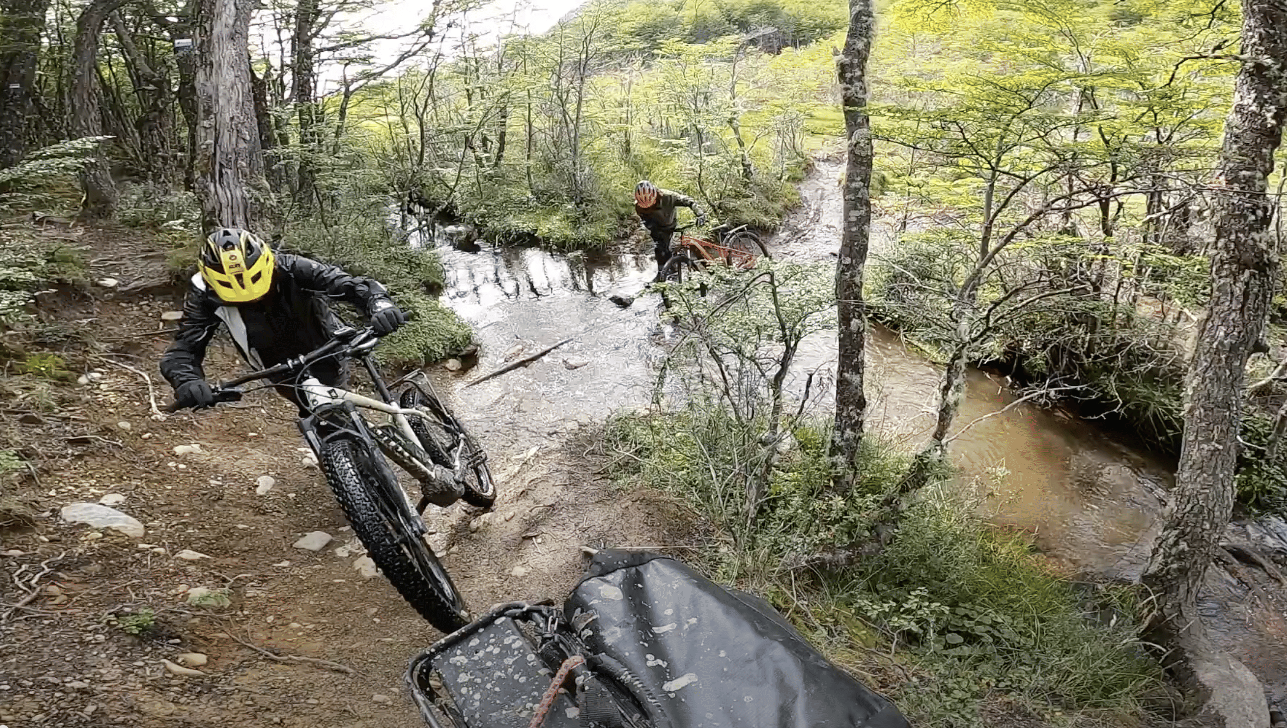 Ciclistas cruzando un arroyo dentro del Bosque cerca de Lago del Desierto
