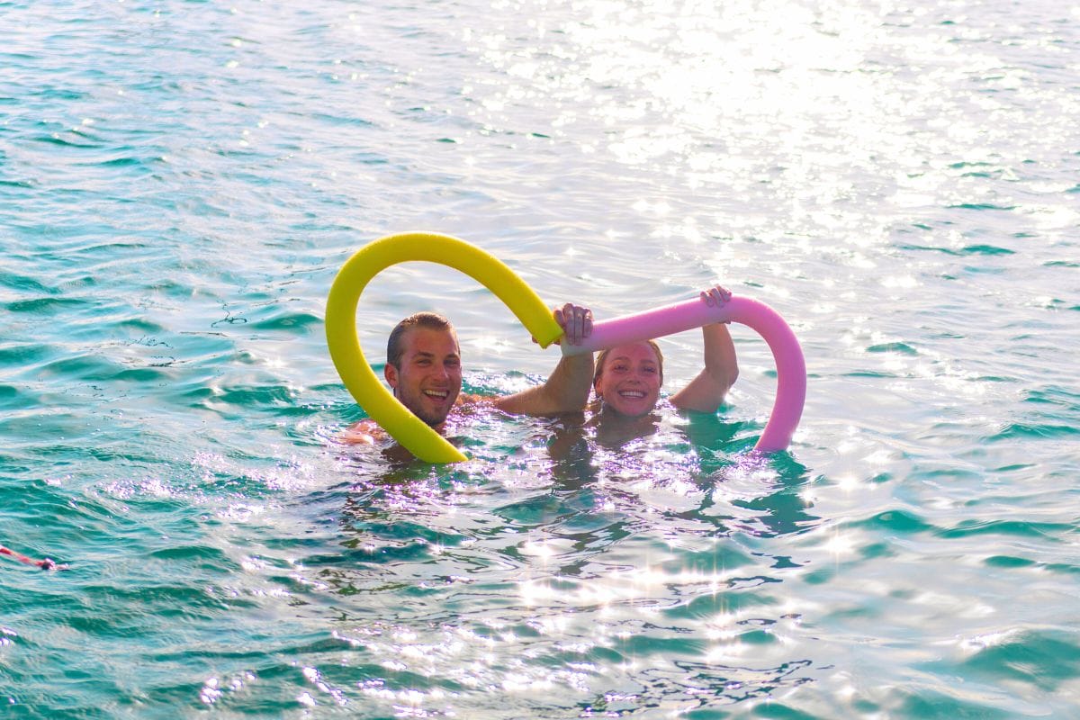 happy couple make a heart shape in the water