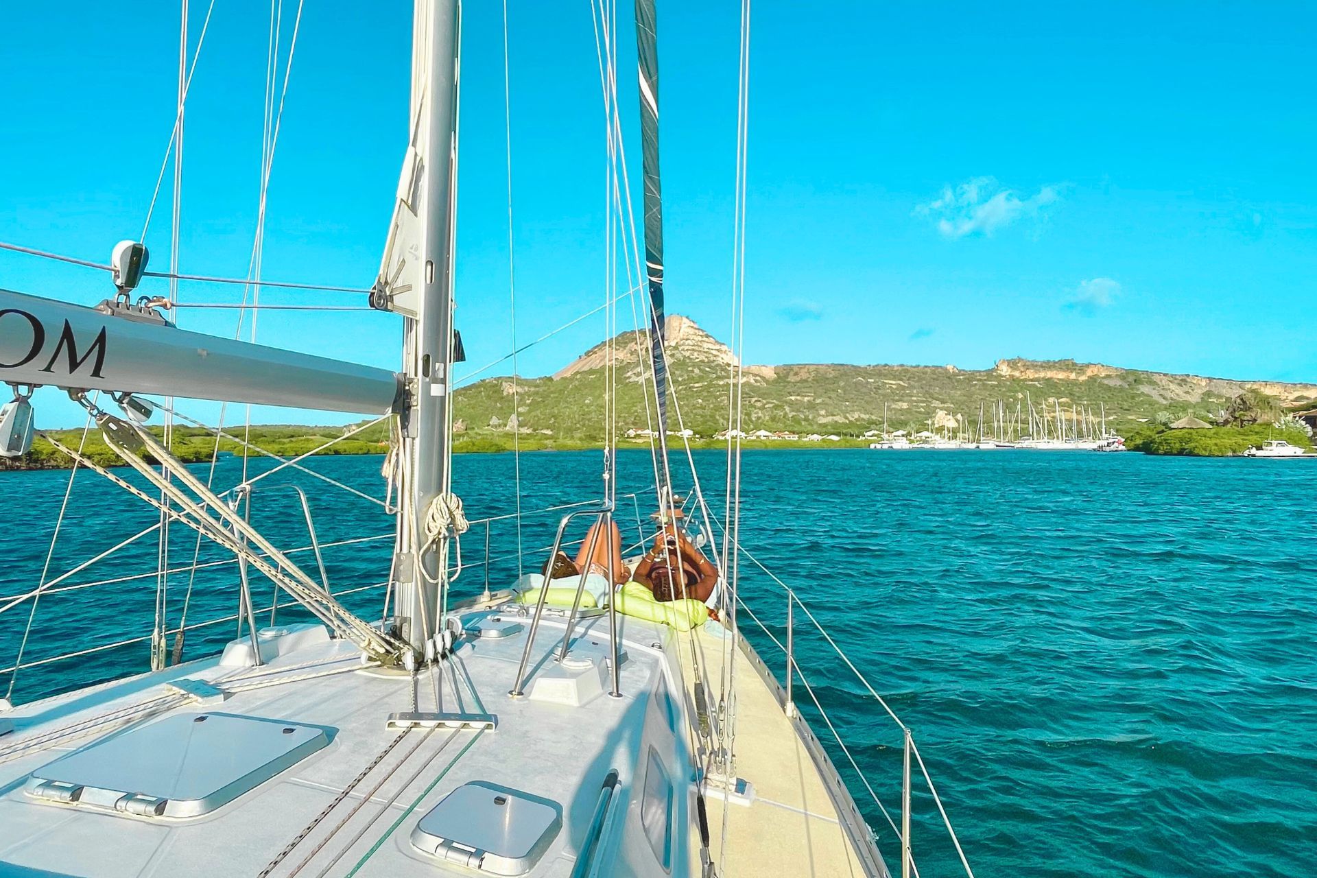 Friends enjoying relaxing in front of sailing yacht in Curacao with Maxie Sailing