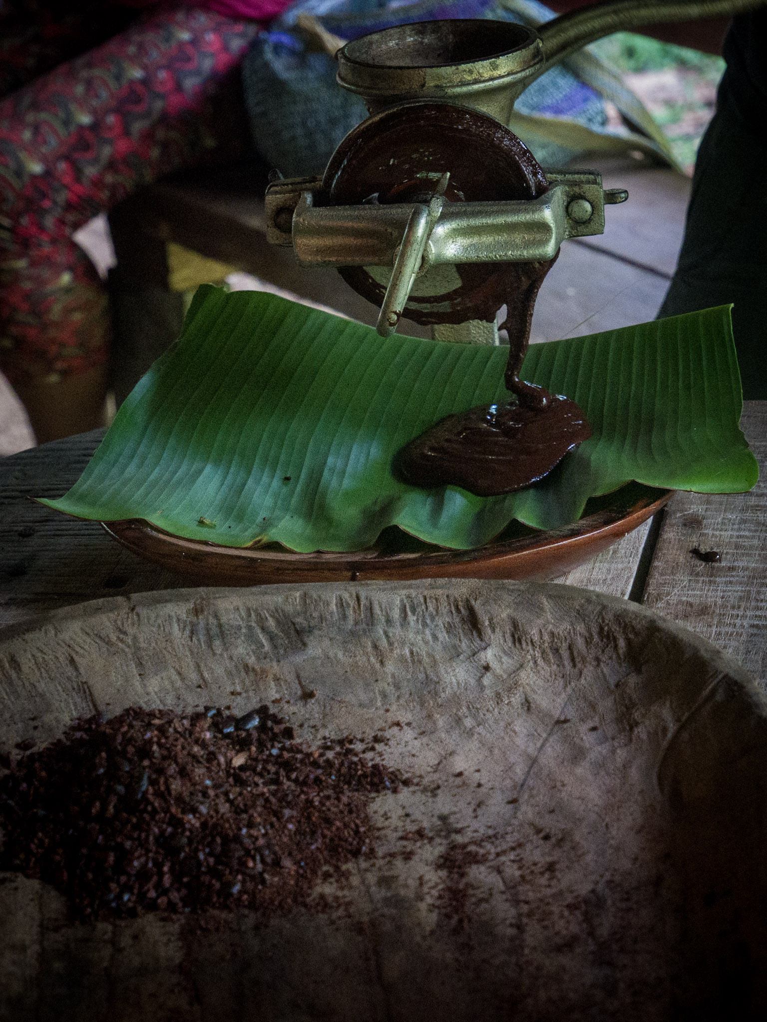 Close-up of traditional cacao grinding on a Bribri cultural tour in Yorkín, Costa Rica, showing fresh chocolate being made on a banana leaf.