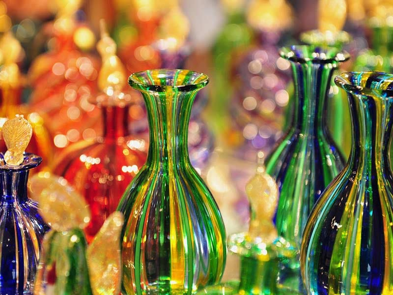 Colorful Murano glass vases displayed in a Venetian workshop