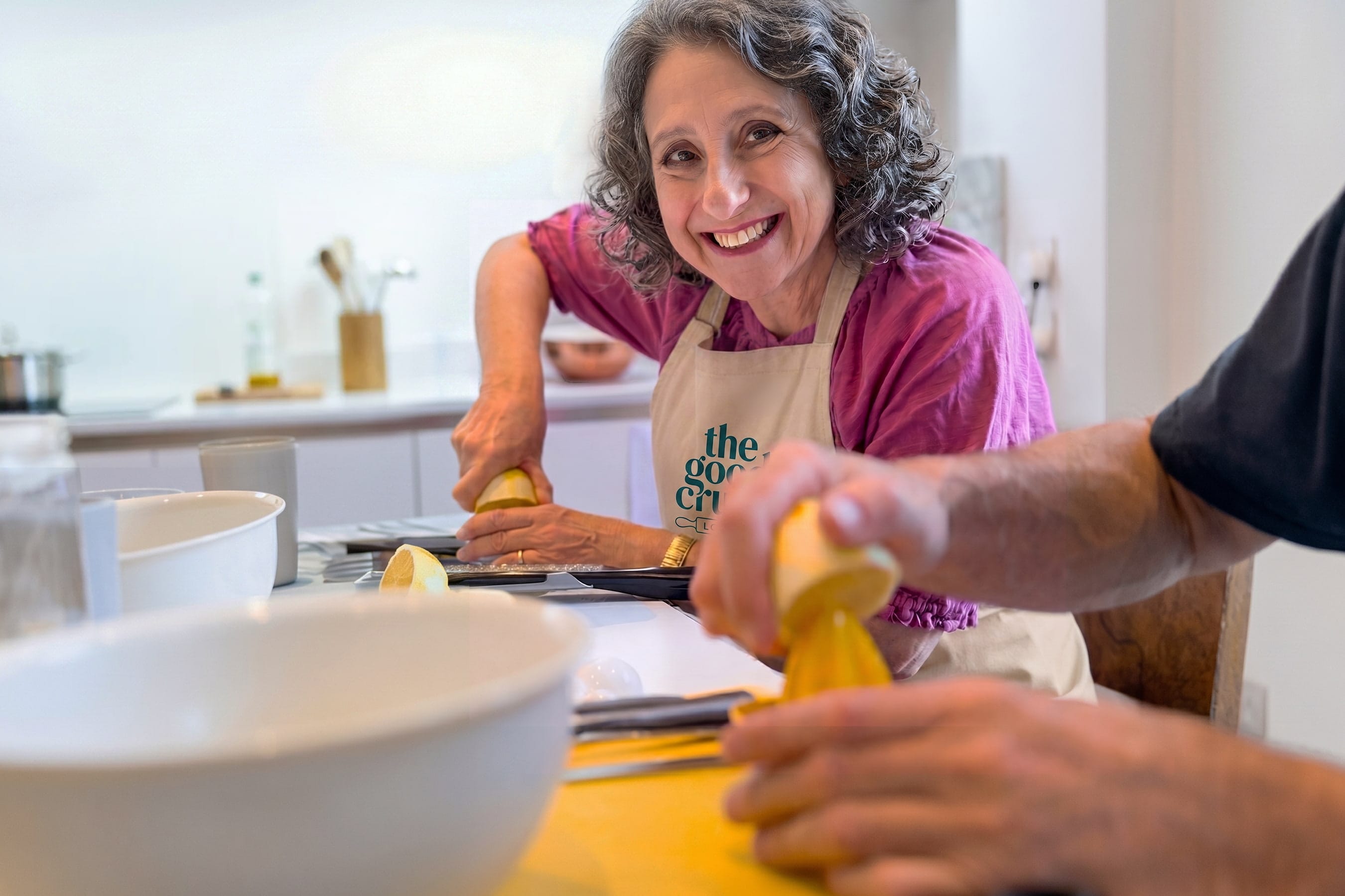 A lady smiling squeezing a lemon to make lemon curd