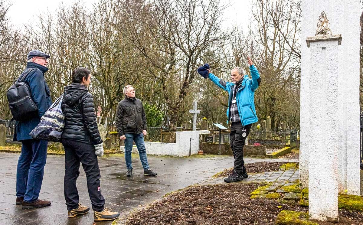 A Guide from Your Friend in Reykjavik telling a story to guests while visiting the oldest Graveyard in Iceland