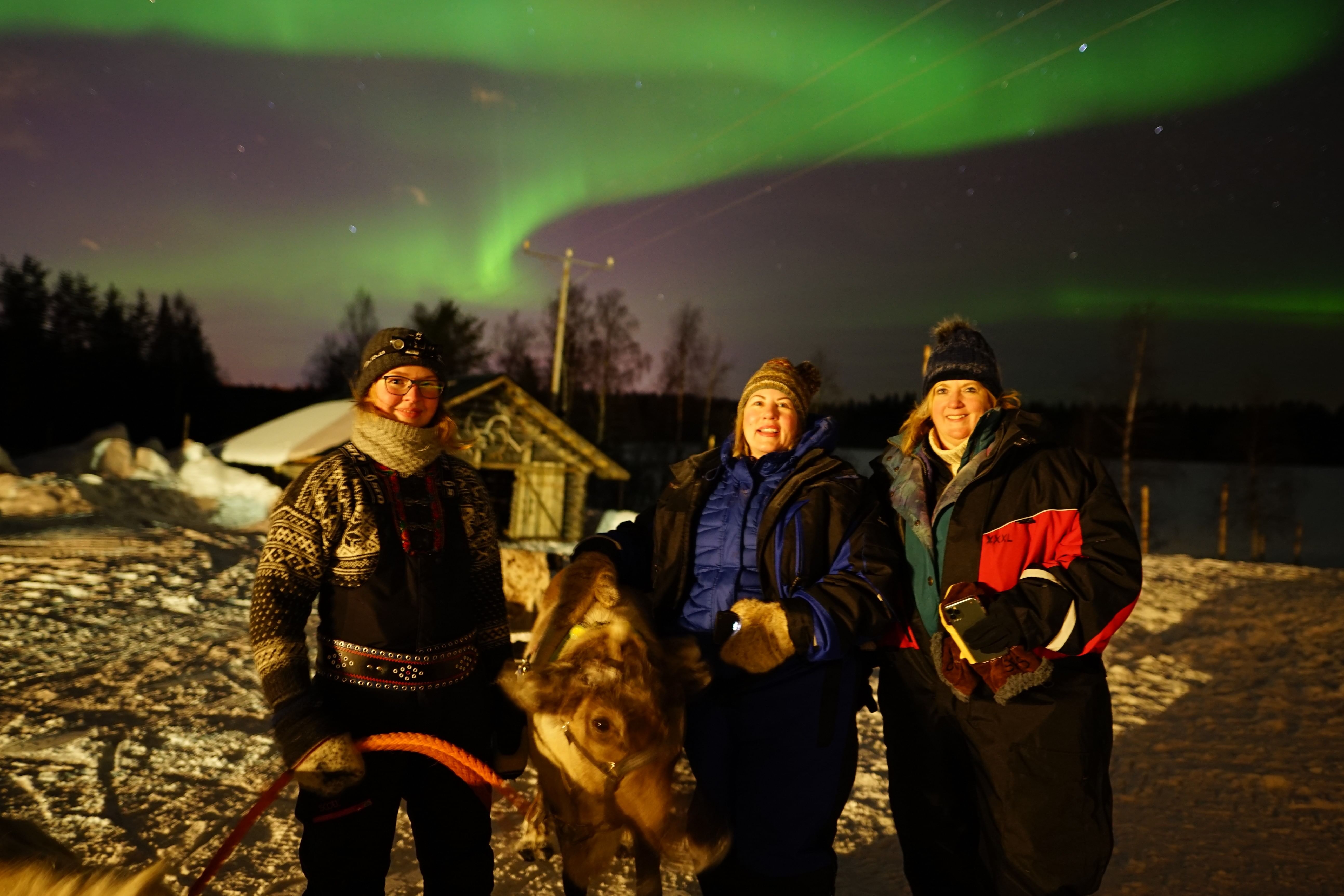 At the reindeer farm with Northern Lights dancing in the sky