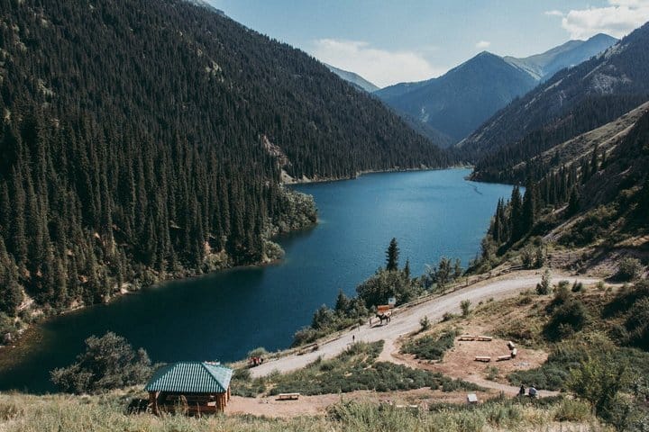 Mountain lake with deep blue water, pine forests, and scenic hiking trails.