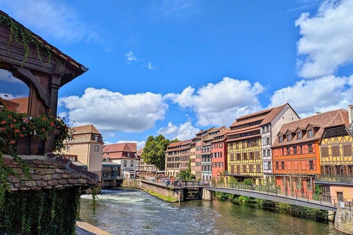 Vue de la Petite France depuis le Pont Saint-Martin, avec maisons à colombages et leurs reflets dans l'eau.