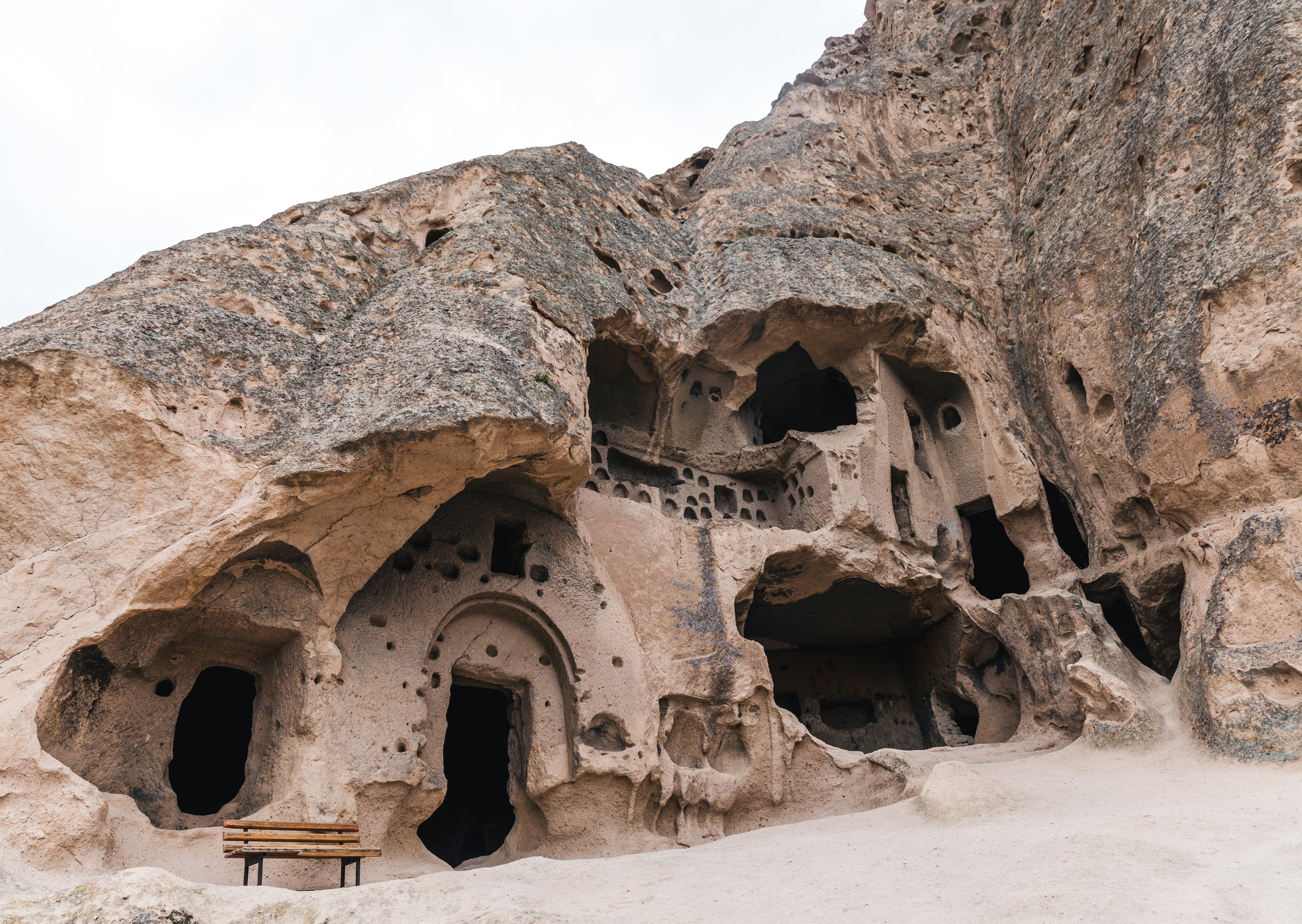 Ancient rock-cut cave openings and distinctive Cappadocia formations.