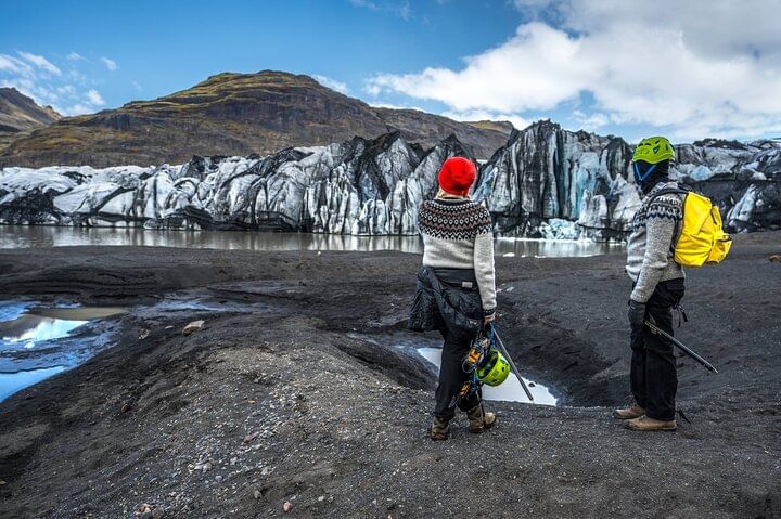 People standing if front of the wall of ice.