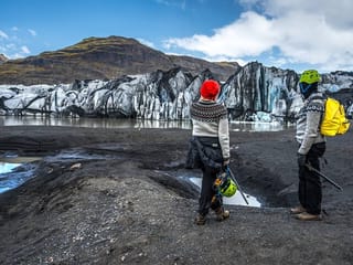 People standing if front of the wall of ice.