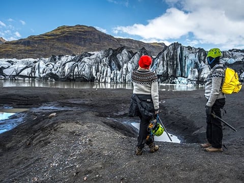 People standing if front of the wall of ice.