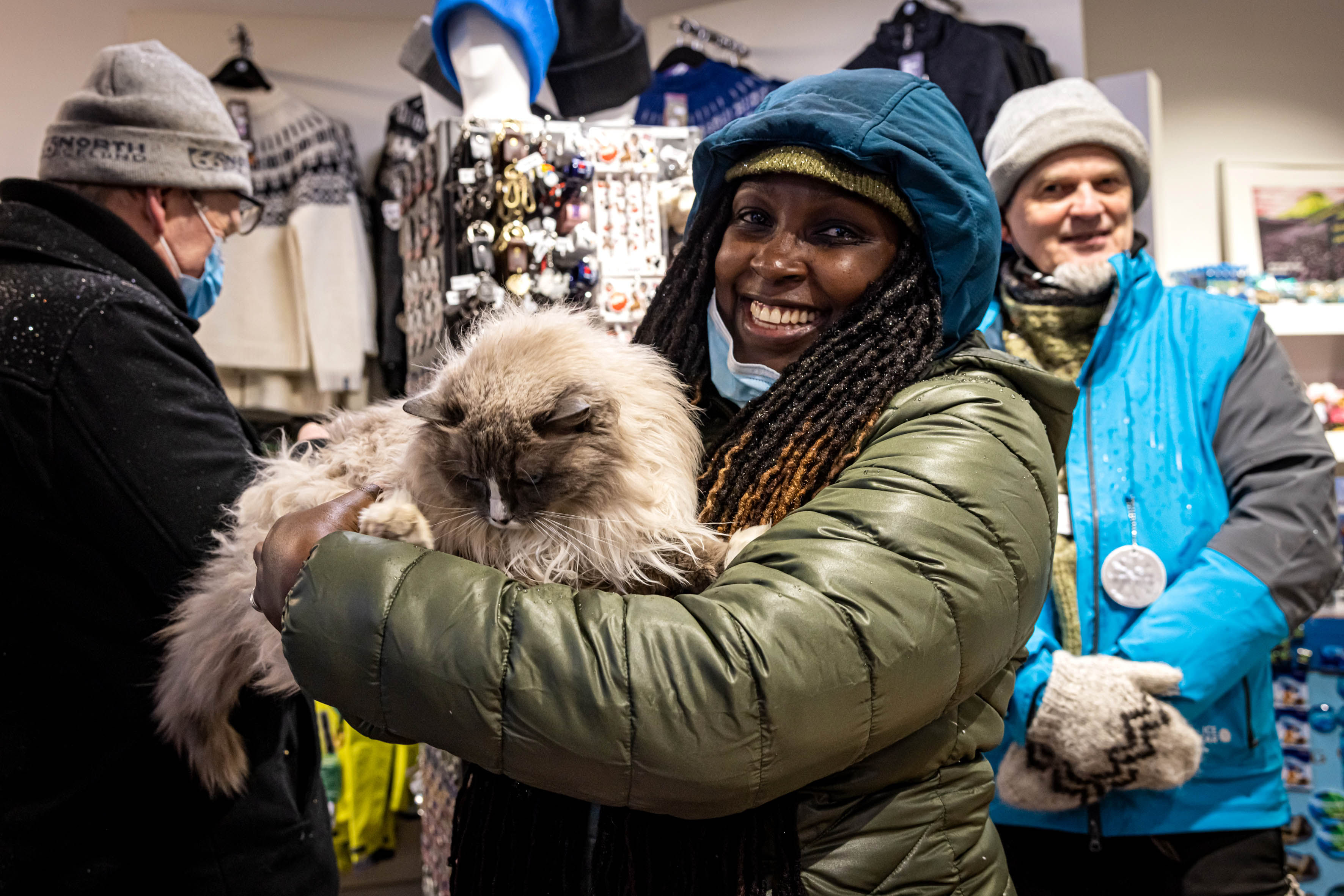 A traveller holding a cat in their arms and smiling