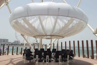 A close-up of a gourmet dish with the Dubai skyline in the background.